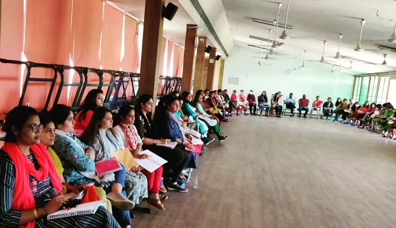 Teachers seated in a circle at an awareness programme